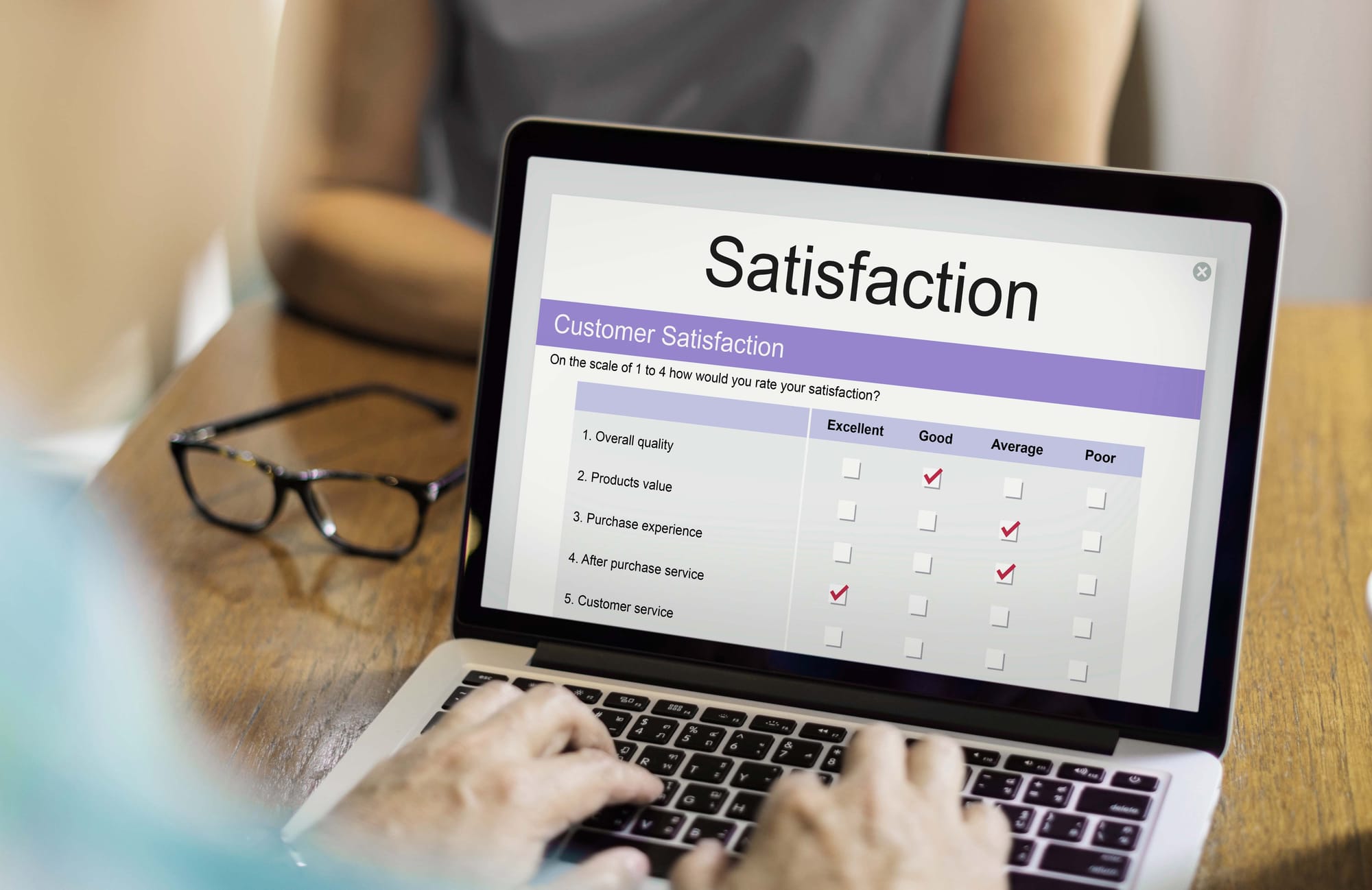 An image showing a laptop that says 'Satisfaction' on the screen.