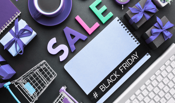 A colorful image that promotes Black Friday. You see gift boxes, coffee cup, notepads, and shopping cart.