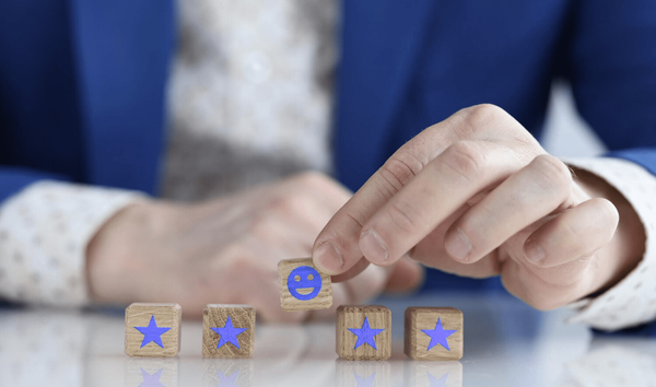 Customer is holding smiling smiley face on wooden cube